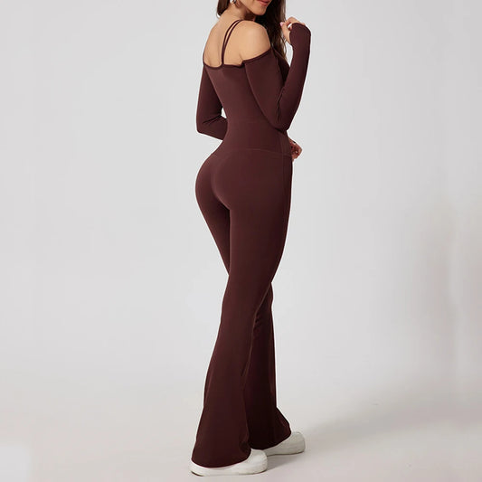 Woman wearing brown open-back summer jumpsuit with long sleeves and full-length legs.